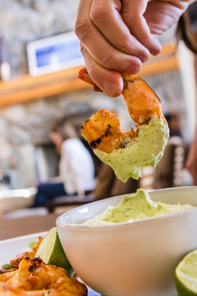 South Lake Tahoe private chef Amy Lynne Power dips chipotle lime-grilled shrimp into her cilantro avocado cream sauce, a dish that’s perfect for a potluck. Photo by Ty O’Neil
