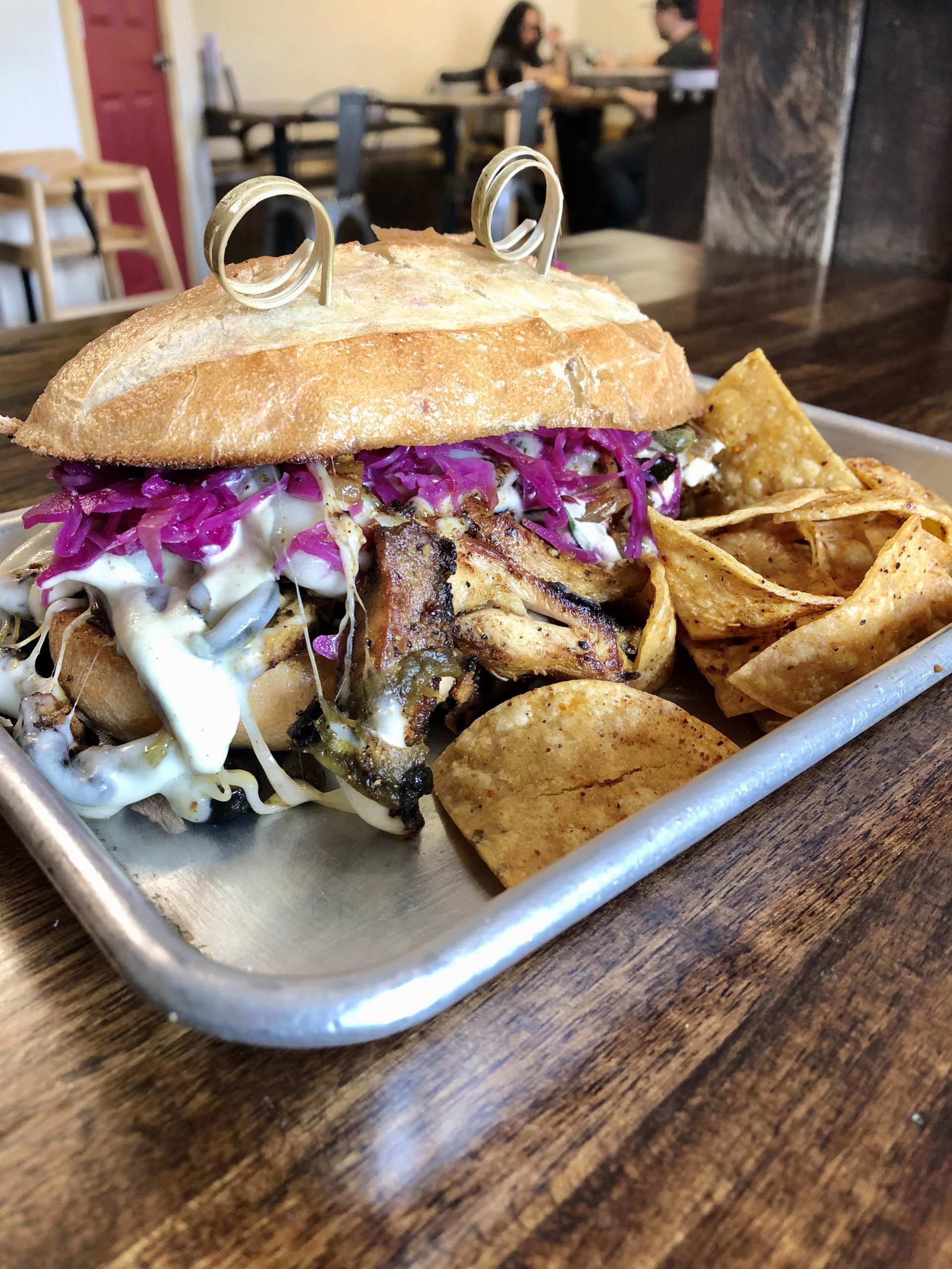 Brickletown chicken (grilled chicken thigh, provolone, peppers, onion, olives, capers, pickled cabbage, and almond dressing) at The Station. Photo courtesy of Grace Burnes at The Station