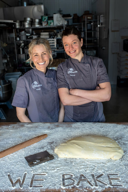 Kristy Kirsh and Daniella Rinaldi, owners of Sierra Bakehouse in Truckee with "WE BAKE" written in flour in front of them