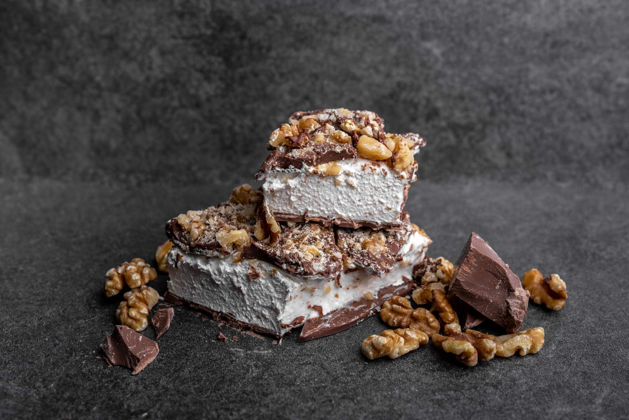 squares of chocolate covered nougat with nut topping