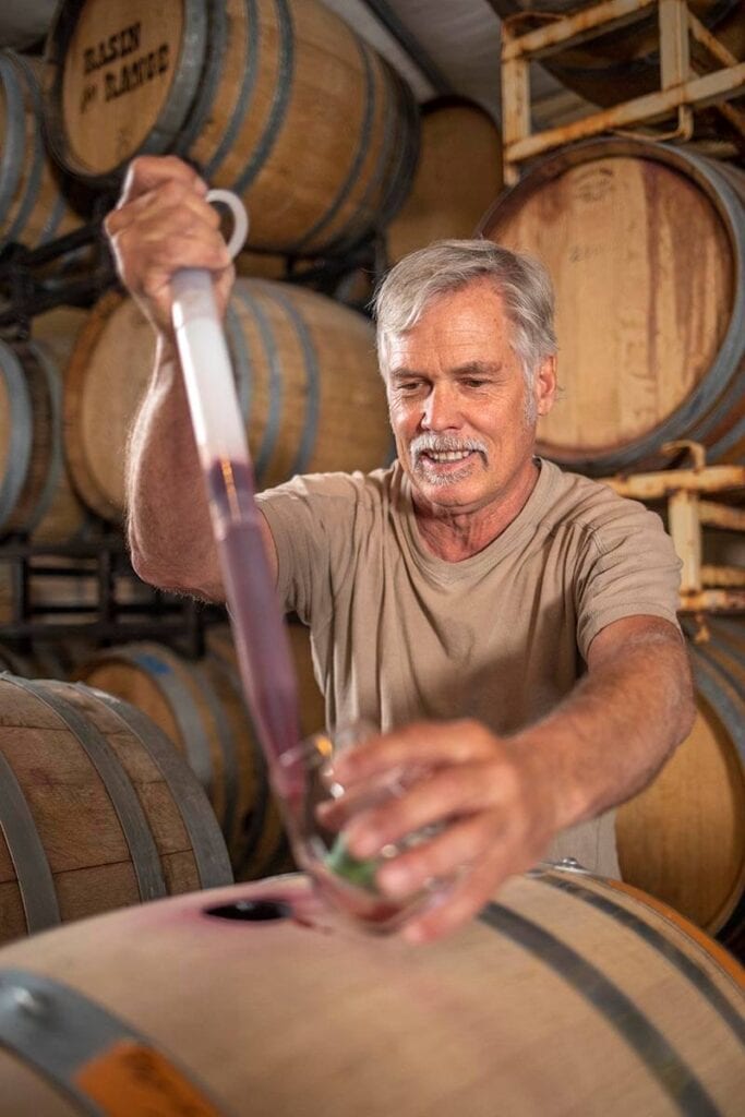 Mike Steedman, co-owner of Nevada Sunset Winery in Reno, pulls a sample of wine from a barrel to test. Photo by Mike Okimoto
