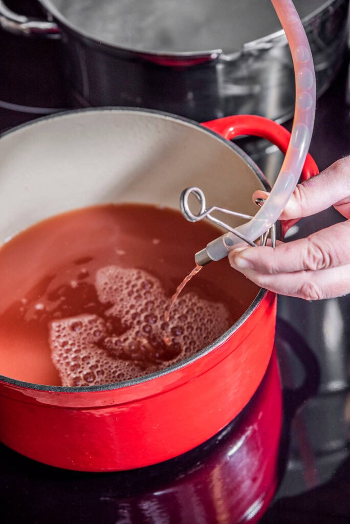Ames fills a pot with the juice collected from the steaming process