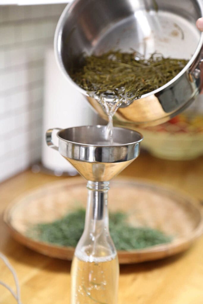 She then strains the needles out of the syrup, so that it’s ready to be poured into a jar for storage in the refrigerator