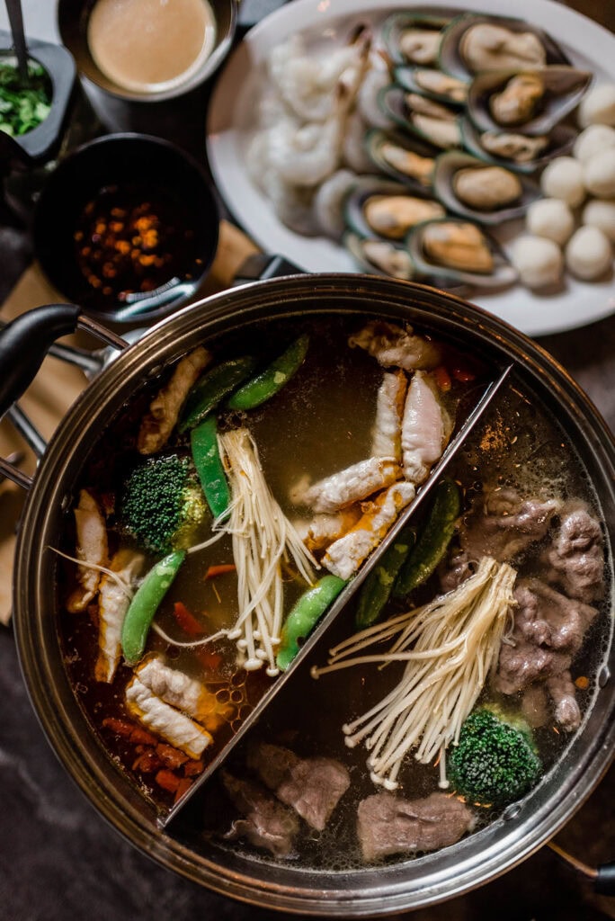 Shabu-shabu hot pot featuring thinly sliced meats, seafood, and vegetables boiled in water and served with dipping sauces