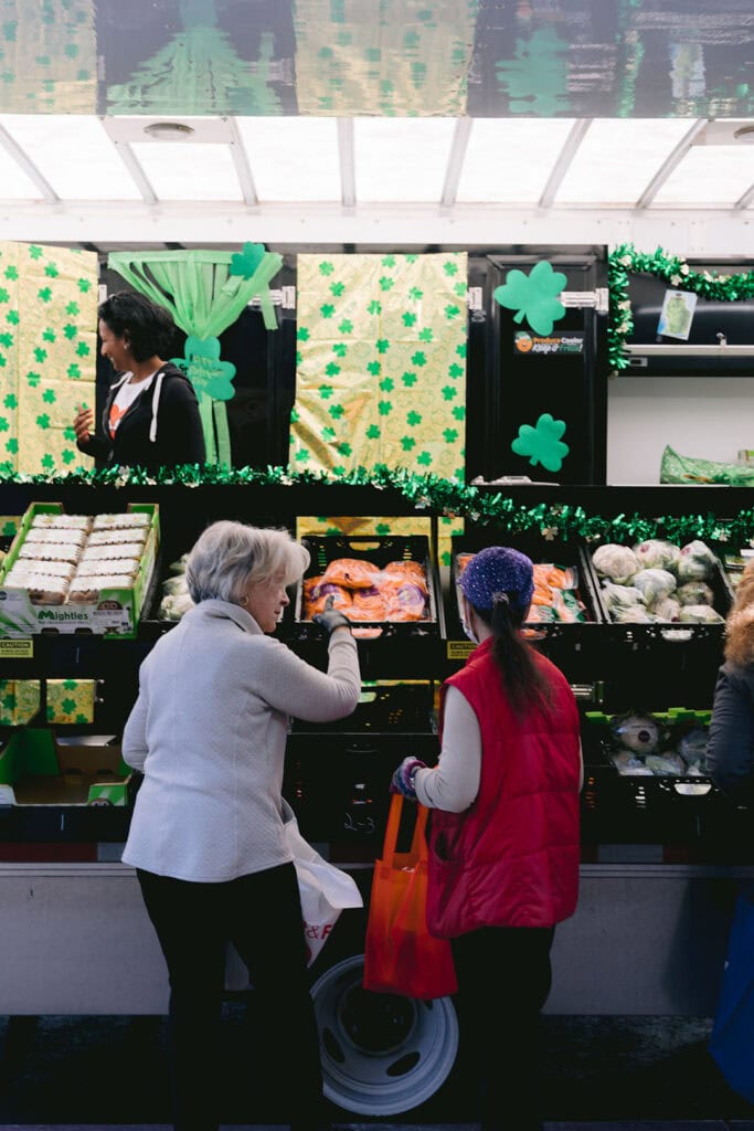 A volunteer helps a senior neighbor select fresh produce