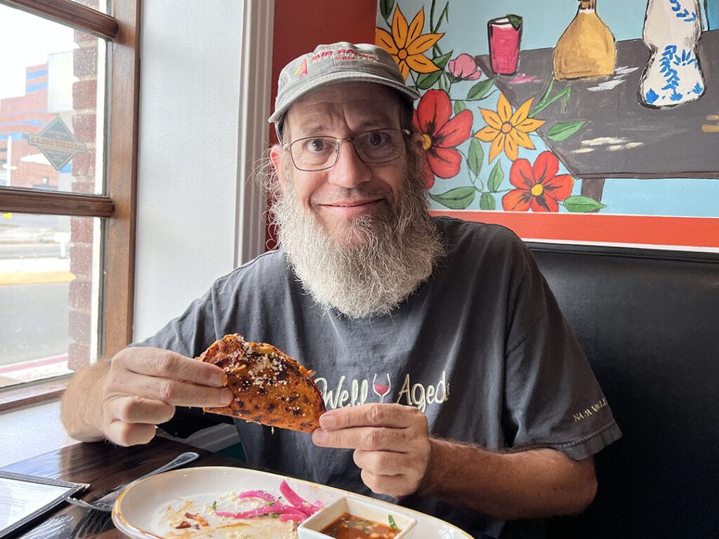Kevin Ashton enjoys a quesabirria taco at Mexcal. Photo by Jaci Goodman