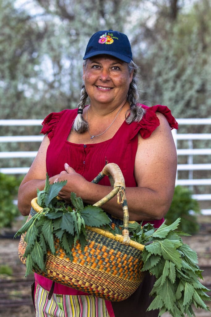 Stacy Fisk carries a basket of her medicinal herbs