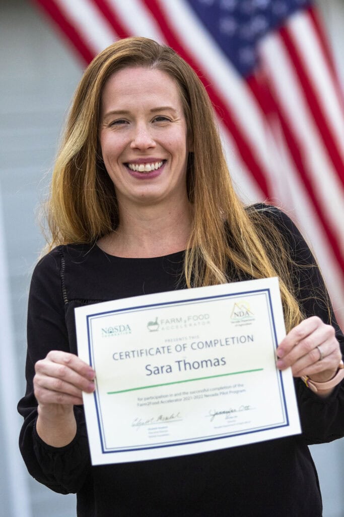 Thomas proudly displays her certificate of completion of the Farm2Food Accelerator program
