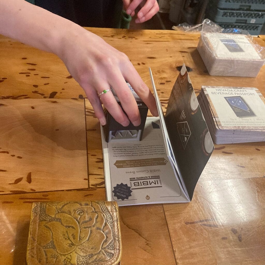 An employee stamps an IMBIB passport for a customer