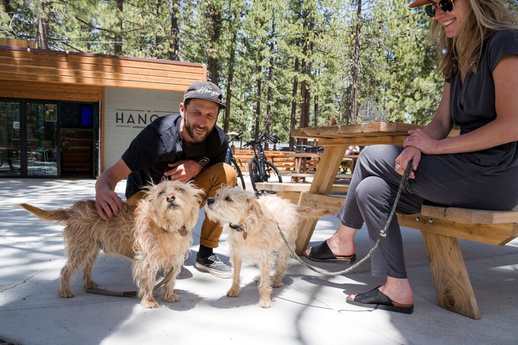 Owners Nate and Nicole Riffle and their two terrier mix pooches, Scotch and Olive, soak up the sun at The Hangar in South Lake Tahoe. Photo by Olga Miller