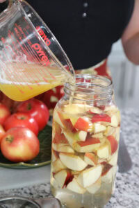 Neubert adds the honey-water mixture to the jar