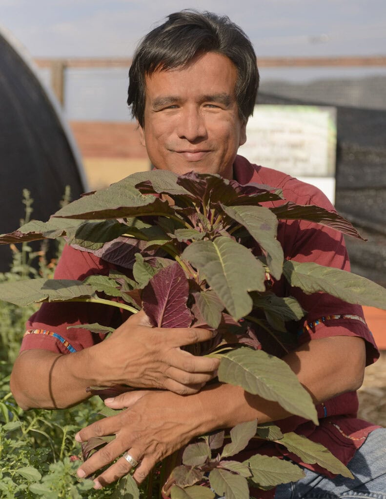 Augustin Jorquez with a Paiute amaranth plant at the community garden in Lemmon Valley