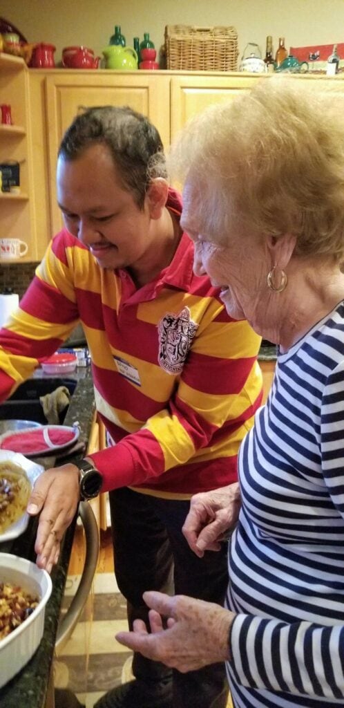 Norma helps a participant from the 2019 Fulbright TEA program try his hand at dinner prep