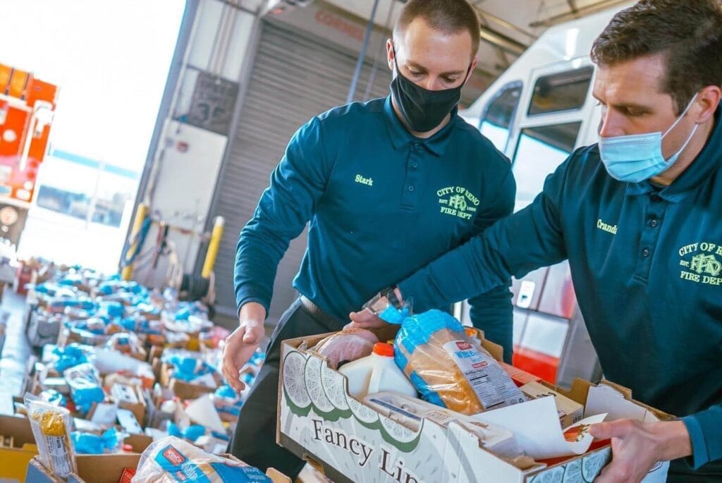 Reno Fire Department firefighters Jack Stark, left, and Tyler Crandall help load boxes during the 2021 Sam Saibini Christmas Food Basket Program