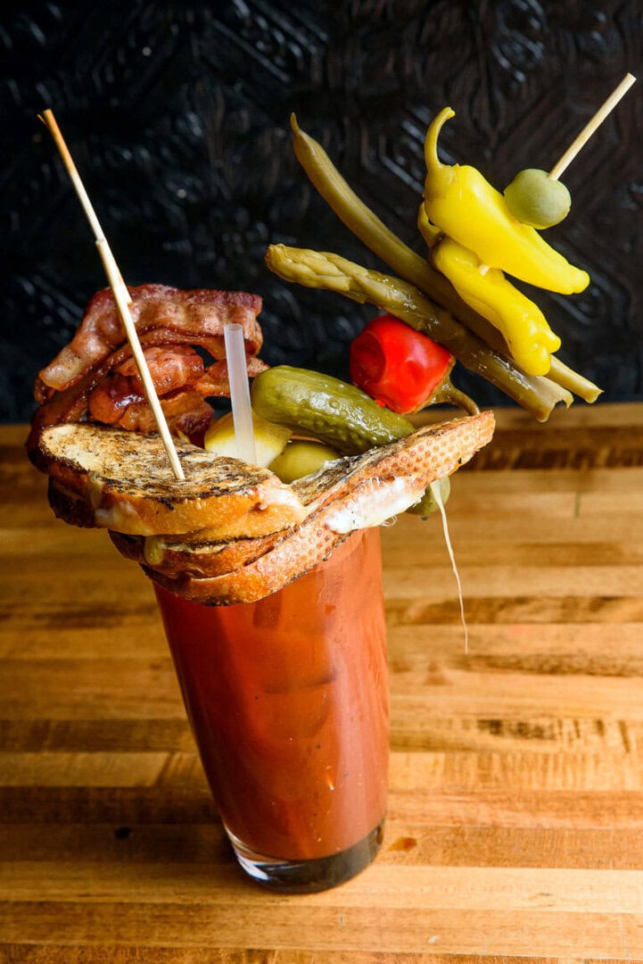 Chapel Tavern's bloody mary is topped with a grilled cheese sandwich, bacon, pickles, peppers, asparagus, string beans, an olive, and a lemon wedge. Photo by Mike Higdon