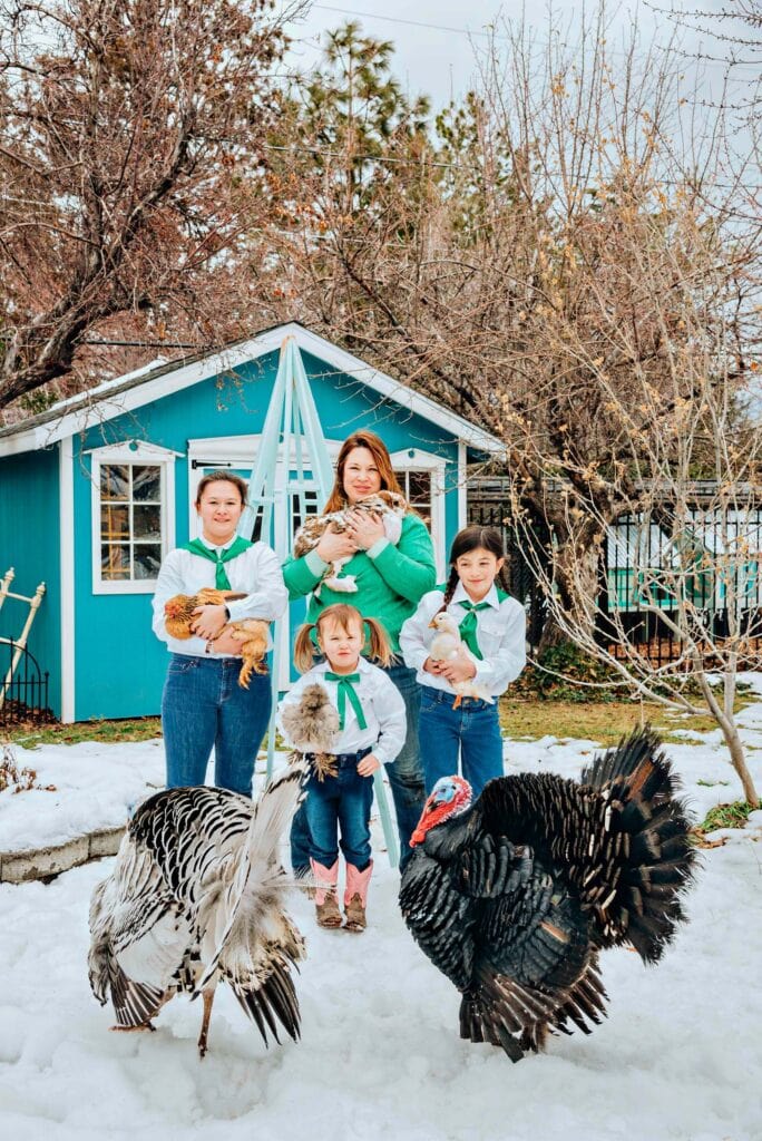Marie Fong, 4-H group leader, and her daughters (from left), Keira, Elora, and Aria, stand outside their Reno home's chicken coop with their chickens, duck, rabbit, and turkeys. Photo by Donna Victor
