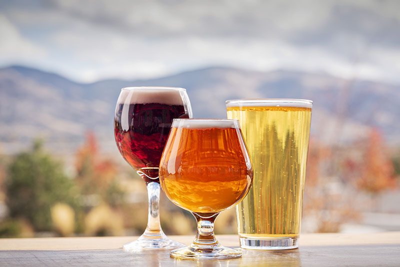 From left, Kasteel Rouge, Alibi Ale Works' Giant Steps, and Pigeon Head Brewing pilsner sit on a patio table at Piñon Bottle Co.'s new South Reno location.