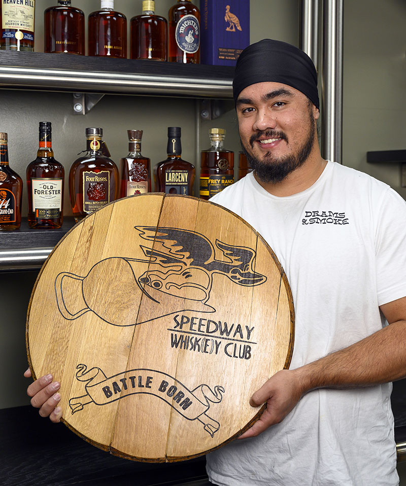 AJ Chhabra holds a barrel head for his Speedway Whiskey Club