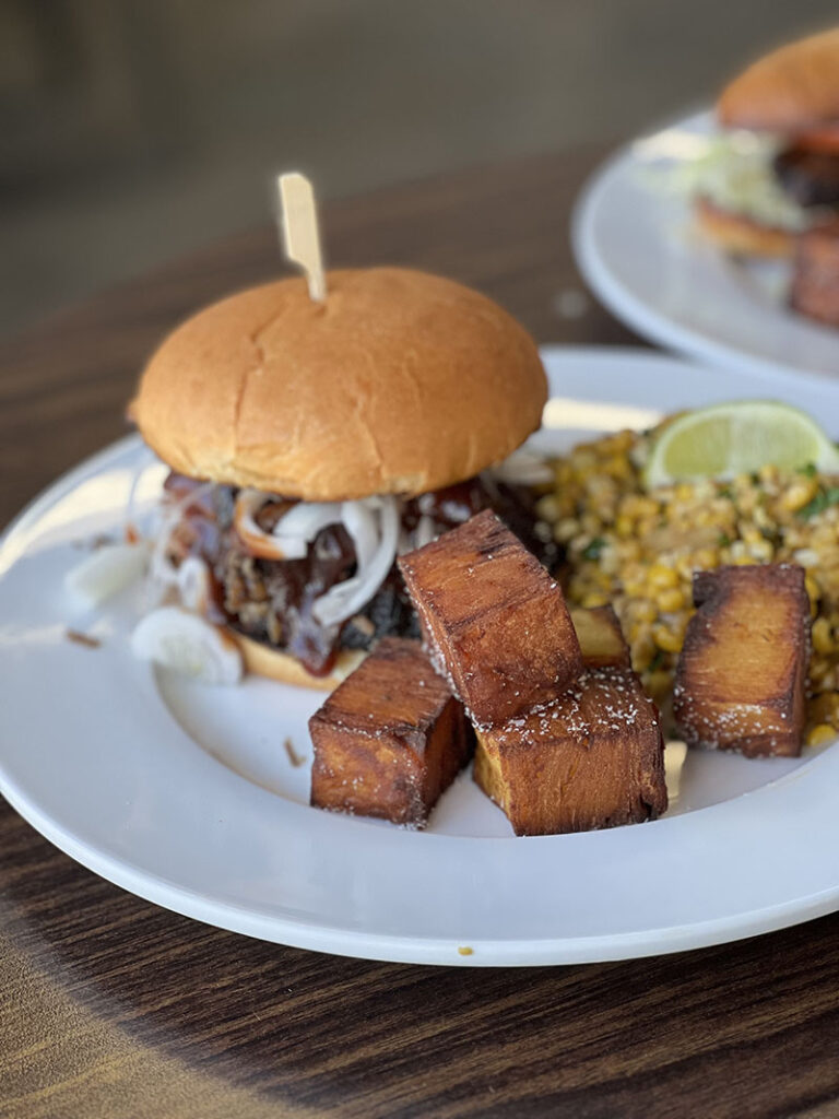 Brisket sandwich served with pavé potato tots and Mexican street corn salad from Big Blue Q. Photo by Dave Santina