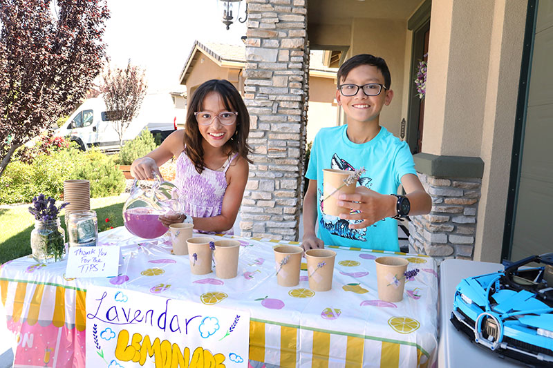 Skye and Aidan Gift pour purple lemonades infused with lavender for their neighbors