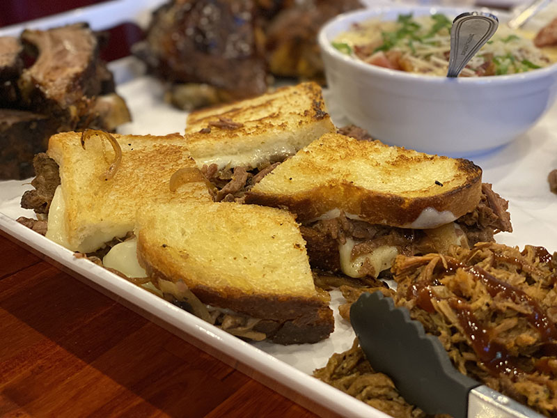 Candied brisket sandwich, sliced brisked, pulled pork, and million-dollar mac at The Phoenix. Photo by Dave Santina