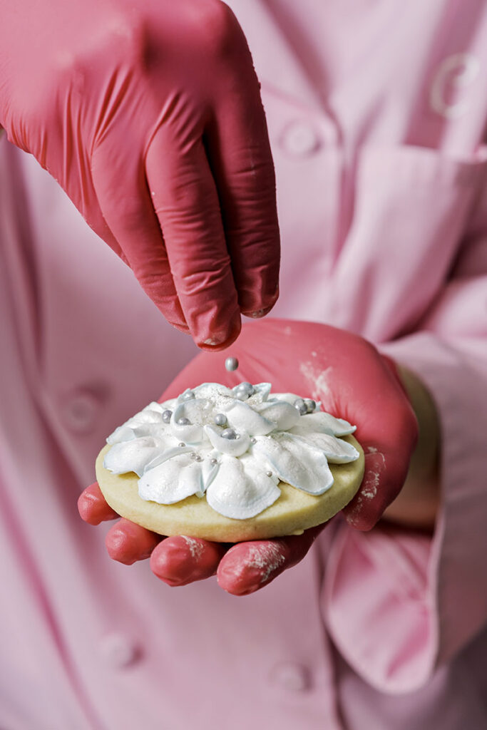 Melvin adds sparkly finishing touches to a cookie