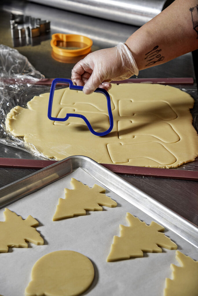 Daters uses cookie cutters to cut her holiday sugar cookies