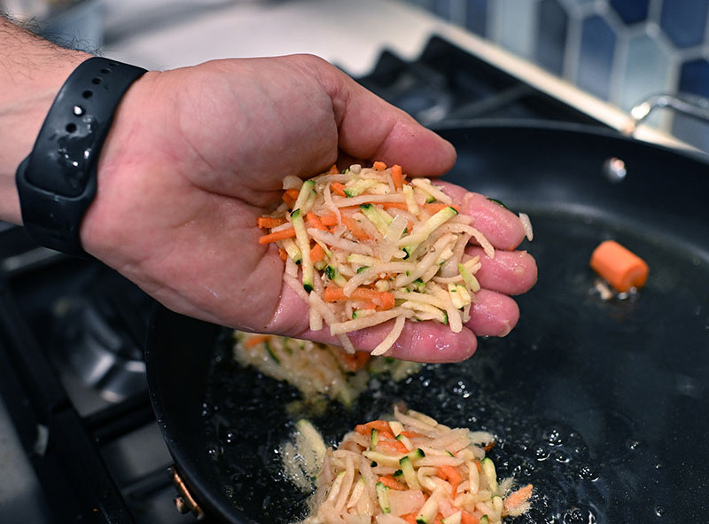 David portions out the grated vegetables to fry in oil