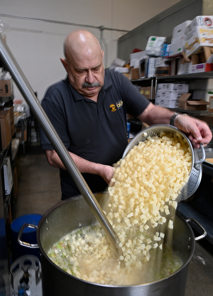 Lee adds 30 pounds of diced potatoes to an 80-quart pot to prepare his locally renowned clam chowder