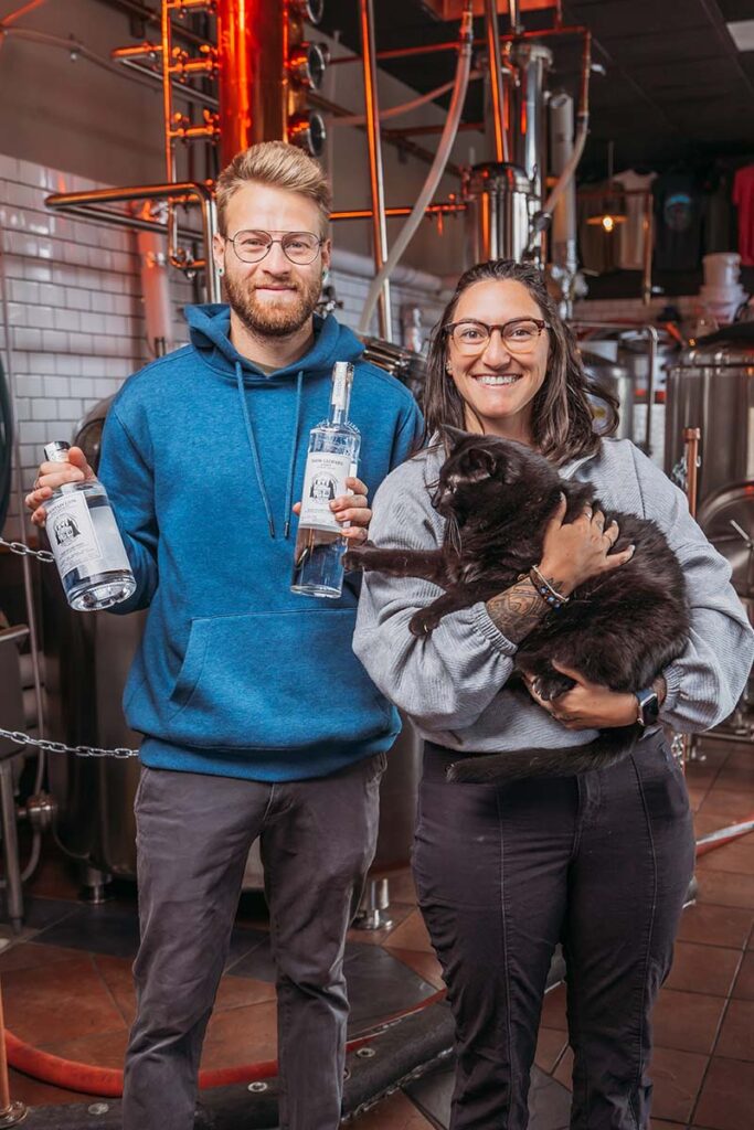 Jonathan Stein, owner and master distiller, with his wife, Katie, and their cat, Socrates, who inspired the name of the business, Shedcat Distillery & Kitchen, in South Lake Tahoe. Photo by Brooke Reyes, Dreampilot Films