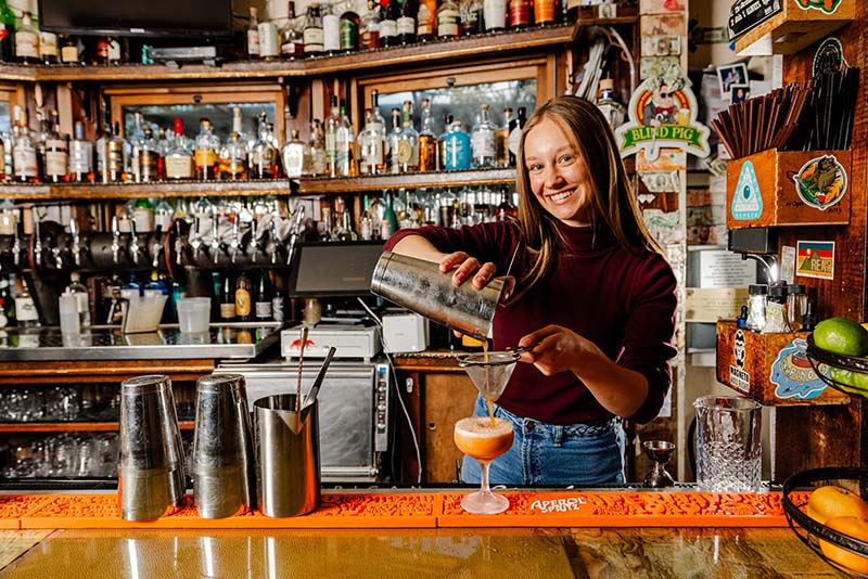 Blythe Dumitru, bartender at Pignic, prepares a city of page mocktail. Photo by Josiah Hassler