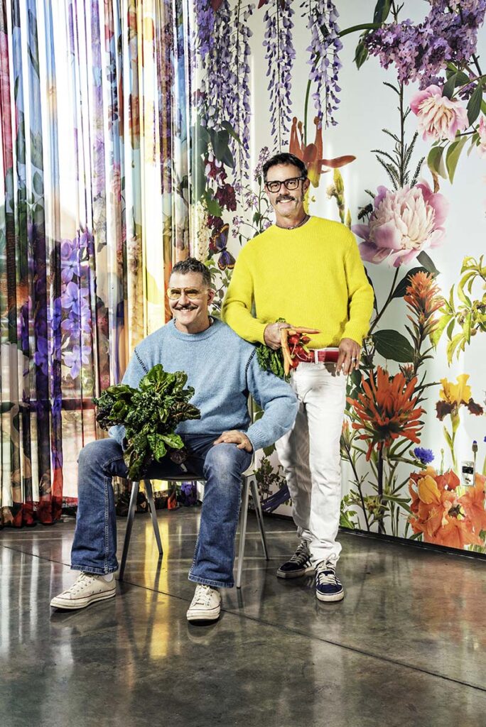 Artists and community collaborators Austin Young and David Allen Burns pose in front of their wallpaper and curtain designs inside Nevada Museum of Art in Reno. Photo by Donna Victor