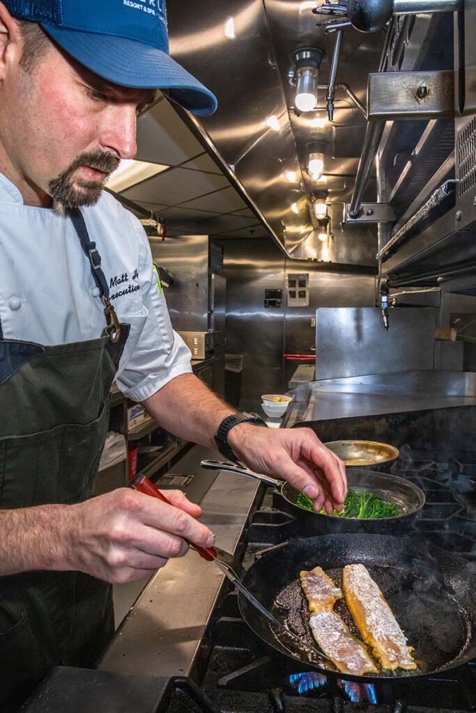 Hale sautés a guest’s rainbow trout, which he’ll serve with meunière sauce on a bed of rice and broccoli. Photo by Scott Thompson