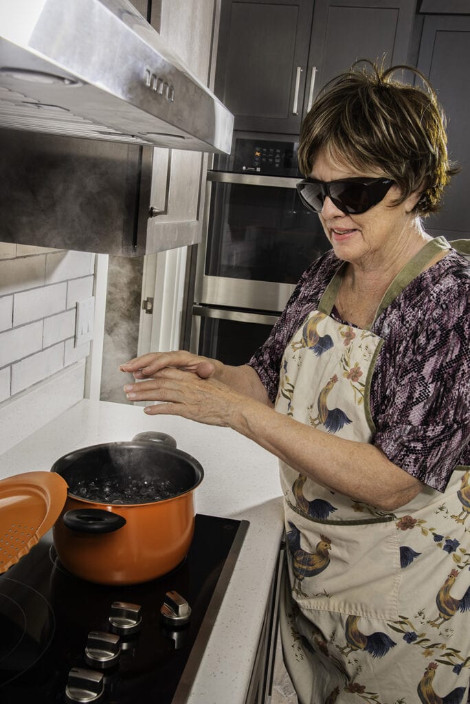 Cooking class student Eileen Edgcomb learned to hold her hands over a pot to make sure it's centered on the stove top and confirm that contents are boiling