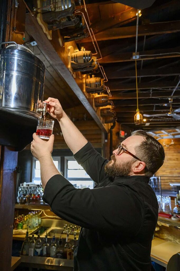 Bar manager Mark Nesbitt pours the boulevardier from the cistern into a crystal glass. Photo by Mike Higdon