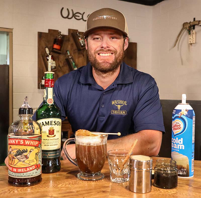 Washoe Tavern owner Ricky Dahlberg proudly presents his Irish coffee, served with cold foam and a rock candy stick. Photo by Lou Manna