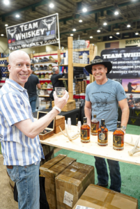A guest enjoys a sample of Team Whiskey poured by cofounder Kevin Stang at the 2025 Team Whiskey Bonanza