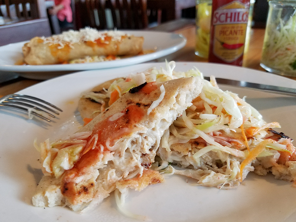 Pupusas are cheese-filled corn patties often eaten for breakfast, which can include chicken and are often topped with cabbage and red sauce